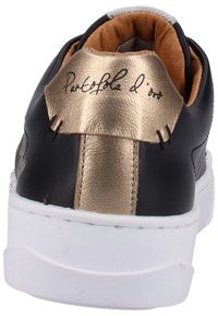 Černá kožená teniska s lesklým zlatým akcentem na podpatku, bílou gumovou podrážkou a hnědým koženým podšívkou. Obsahuje podpisový detail na zadní straně.