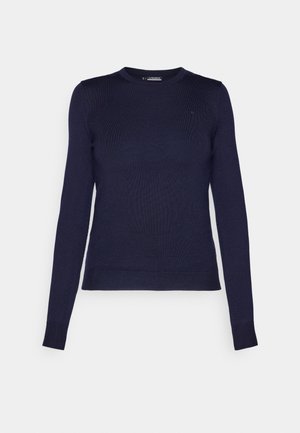 Mörkblå långärmad tröja med ribbat mönster, rund halsringning och figurnära design. Har en liten logotyp på övre vänstra bröstet.