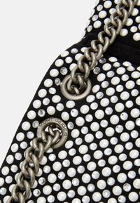 Borsa in tessuto nero decorata con perle bianche e strass trasparenti. Dotata di tracolla a catena metallica e dettaglio con marchio distintivo.