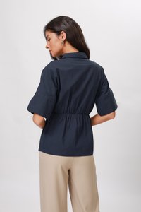 Camicia blu navy a maniche corte con vita sdrucita. Realizzata in tessuto liscio, presenta un colletto alla mandarina e una vestibilità comoda.