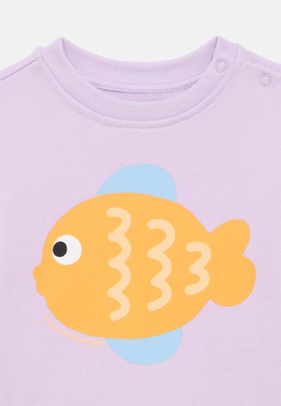 Purple crew-neck shirt featuring an orange fish graphic with wavy lines, a blue fin, and a white text label "STELLA McCARTNEY."