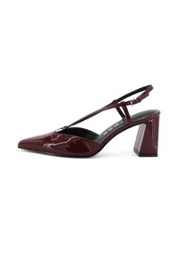 Décolleté in vernice bordeaux con punta a mandorla e tacco quadrato chunky. Presenta una sottile fascia regolabile.