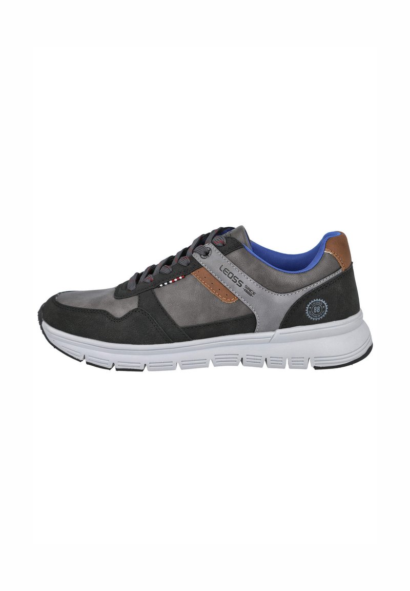 Zapatilla deportiva para hombre con parte superior de ante y material sintético en tonos gris y negro, con un detalle marrón, entresuela blanca y forro interior azul.