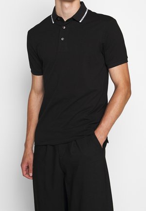 Polo shirt nera in misto cotone con colletto a contrasto che presenta un logo. Maniche corte, design aderente e apertura con due bottoni.