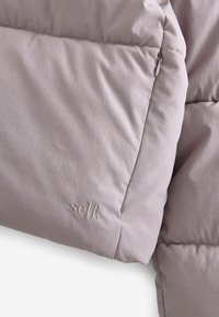 Gaiši violetas pūkains džemperis ar quilting tekstūru, piedāvājot smalku izšūtu logotipu "self." un sānu rāvējslēdzēju.