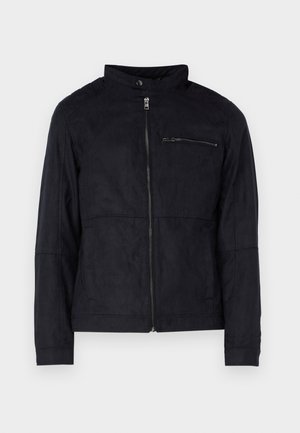 Črna jakna iz materiala, ki spominja na usnje, z dvignjenim ovratnikom, sprednjim zadrgo in žepom na prsih z zadrgo. Preprost dizajn s prilagojenim krojem.