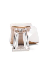 Sandal con tacco a blocco trasparente, con tomaia in sintetico bianco e suola nude. Presenta un tacco trasparente unico e una texture liscia.