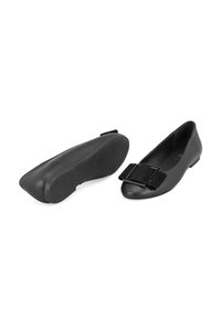 Zwarte faux leren ballerina's met een ronde neus, voorzien van een opvallende zwart fluwelen strik en een lage, platte rubberen zool.