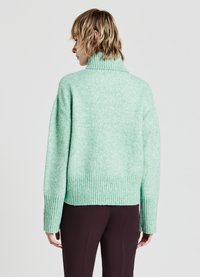 Maglione lavorato a maglia verde menta con colletto a imbuto e orlo a coste. Presenta spalle cadute e una vestibilità rilassata, realizzato in un morbido materiale testurizzato.
