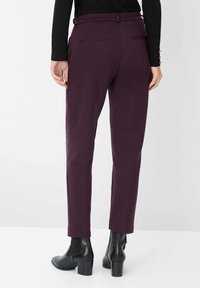 Burgunderfarbene maßgeschneiderte Hosen mit einem strukturierten Muster, ausgestattet mit Gürtelschlaufen, seitlichen Taschen und einer schlanken, geraden Passform.