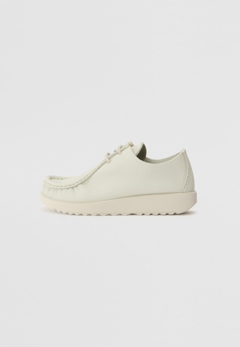 Sapatos de couro em tom bege claro com acabamento texturizado, bico arredondado, design de atacadores minimalista e sola de borracha leve com um padrão de ranhura.