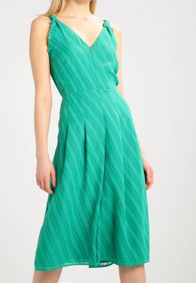 Robe verte avec un décolleté en V, des bretelles et un motif texturé ondulé. Mi-longue avec un corsage ajusté et une jupe évasée.