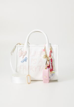 Sac à main blanc avec poignées courtes et bandoulière détachable, décoré de patches roses et bleus, de porte-clés, et de la phrase "La vie est un conte de fées."