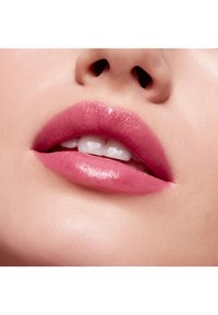 Close-up van gladde, roze lippen met een glanzende afwerking, voorzien van zachte contouren en een subtiele gradient effect. De huidtint lijkt egaal en helder.
