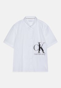 White short-sleeve button-up shirt with Calvin Klein Jeans logo in large grey letters on the right side near the bottom.