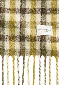 Écharpe en laine tissée présentant un motif à carreaux avec des nuances de crème, olive et bordeaux. Finition avec des bords frangés et une étiquette de marque.