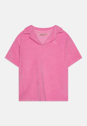 Ροζ κοντό πόλο μπλουζάκι από μαλακό ύφασμα, με γιακά, κοντά μανίκια και μια μικρή λογότυπο λεπτομέρεια μπροστά.