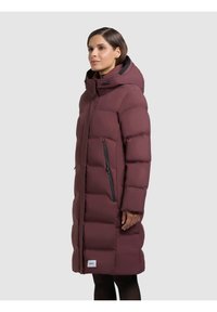 Palton lung puffer burgund cu glugă, cu fermoar în față și buzunare laterale, design matlasat și accente hardware negre contrastante.