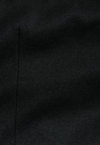 Black fabric with a smooth texture and subtle sheen. The surface shows slight variations, likely from woven fibers, with minimal wrinkles.