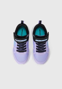 Baskets de sport lilas avec un design en mesh, des accents noirs et des lacets noirs. Présente une sangle noire avec le logo "Skechers" dessus.