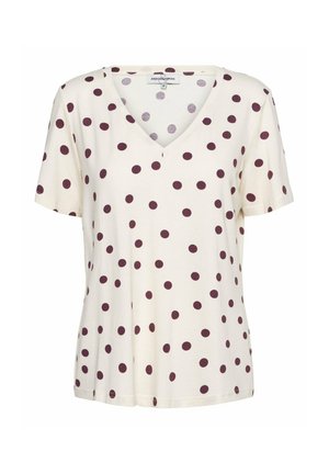 Crèmekleurige dames top met korte mouwen en een V-hals met verspreide donkerpaarse polkadots, losse pasvorm en label "ANDCOWOMAN" aan de binnenkant van de kraag.
