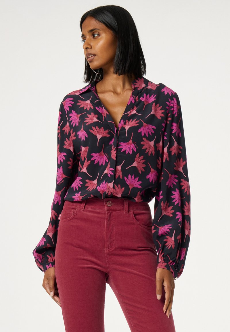 Zwarte blouse met een roze bloemmotief, lange mouwen, knoopsluiting aan de voorkant, gecombineerd met bordeauxrode corduroy hoge taille broek, met een gestructureerde stof.