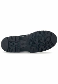 Semelle de chaussure en caoutchouc noir avec une surface texturée présentant plusieurs motifs, un design de semelle distinct et le logo "Gabor" au centre.