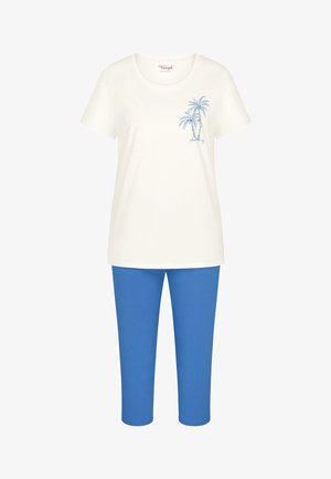 Biały top z krótkim rękawem z niebieskim nadrukiem palmy zestawiony z jednolitymi, niebieskimi spodniami o kroju cropped.