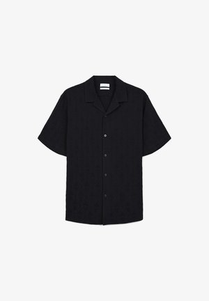 Chemise noire à manches courtes avec un motif texturé géométrique, fermeture à boutons et un design de col camp. Présente des accents tonals discrets.