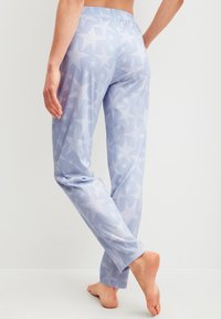 Lichtblauwe pyjamabroek met een sterrenpatroon, met een zachte textuur en een elastische tailleband. De pijpen zijn recht en van volledige lengte.
