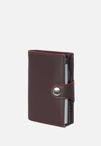 Bruine leren portemonnee met een drukknoopsluiting, voorzien van rode stiksel en geschikt voor meerdere kaarten. Compacte rechthoekige vorm, gladde textuur.