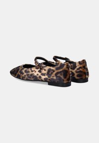 Bailarinas de estampado de leopardo hechas de tela suave, con punta afilada, diseño de doble tirante y un bajo tacón negro.
