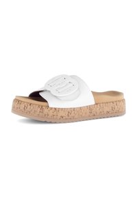 White slide sandal with a wide strap featuring a raised, textured buckle. Cork-like sole with a light brown color and subtle textured pattern.