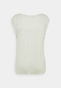 Světle zelená košile s krátkým rukávem, vyrobená z strukturované tkaniny, s jemným tečkovaným vzorem a nařasenými detaily na spodním okraji.