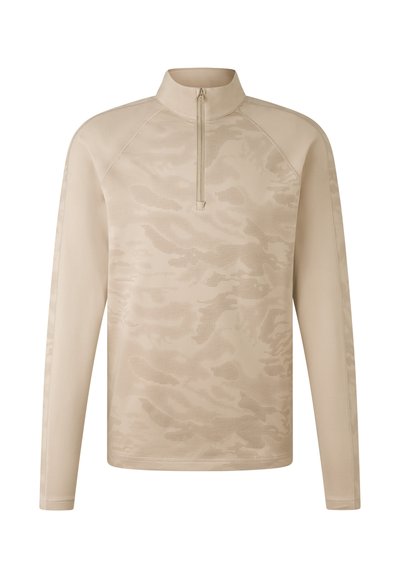 Beige long-sleeve top with a half-zip collar, featuring a textured camouflage pattern and raglan sleeves for enhanced movement.