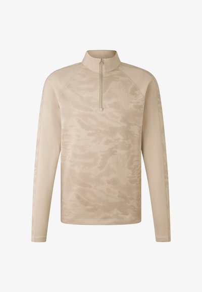 Beige long-sleeve top with a half-zip collar, featuring a textured camouflage pattern and raglan sleeves for enhanced movement.