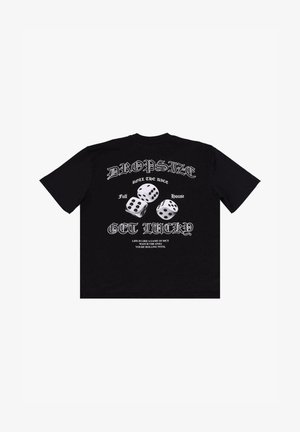 T-shirt en coton noir avec un col rond. Présente un imprimé graphique blanc de dés et du texte dans le dos, avec une coupe décontractée.