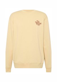Sudadera amarilla de cuello redondo con puños y dobladillo de canalé. Presenta la impresión "Do Nothing Club" en marrón en el lado izquierdo del pecho. Material suave de mezcla de algodón.