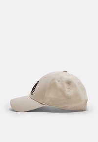 Casquette de baseball beige avec visière courbée et le numéro "94" brodé en noir à l'avant, présentée sur un fond blanc.