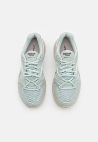 Light green mesh and synthetic sneakers with beige sole, featuring rounded toes, lace-up front, and branded insoles.