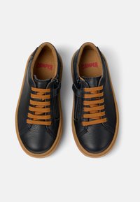 Zapatillas de cuero negro con cordones naranjas y cremallera, parte superior texturizada, suela de goma y marca roja en la plantilla.