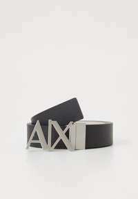 Schwarzer Ledergürtel mit breitem Riemen und einer silbernen Metallschnalle mit geometrischem "AX"-Logo. Glatte Textur, minimalistische Stilrichtung.