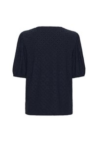 Tumši zila blūze, kas izgatavota no teksturēta auduma ar izgrieztiem ziedu rakstiem, ar īsām pūkainām piedurknēm un taisnu apakšmali.