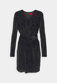 Robe en velours noir avec un décolleté en V profond, des manches longues et une taille cintrée. Elle présente un motif floral texturé et une fermeture éclair sur le côté.