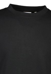Camiseta negra de cuello redondo hecha de algodón. Textura suave con un color sólido y sin patrones o gráficos visibles. Mangas cortas y ajustadas.