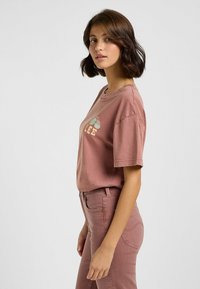 Rosa Baumwoll-T-Shirt mit kurzen Ärmeln, Rundhalsausschnitt und einem Grafikdesign mit dem Wort "LEE" und Kaktusmotiven auf der Vorderseite.