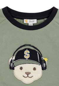 Felpa verde con colletto a coste neri; presenta un orso ricamato e testurizzato con cuffie e un berretto nero con un logo.