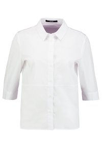 Vit bomullsskjorta med spetsig krage, korta ärmar och knäppning fram. Har en slät textur och en skräddarsydd passform.