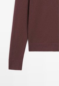 Tmavě červený svetr s rukávem, který má žebrovaný manžet a lem, vyrobený z hladkého textilu s jemnou pletenou texturou. Jednoduchý, elegantní design.