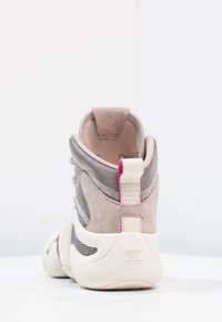 Wysokie sneakersy z szarym meshowym wierzchem, z akcentami z zamszu, różową pętelką na pięcie oraz białą gumową podeszwą z teksturowanym wykończeniem.